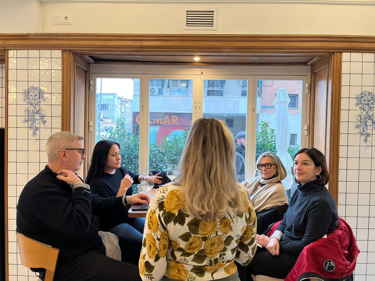 Cristina Barrero explaining the wine selection to her four guests seated at a table during the Tapas and Wine Experience.