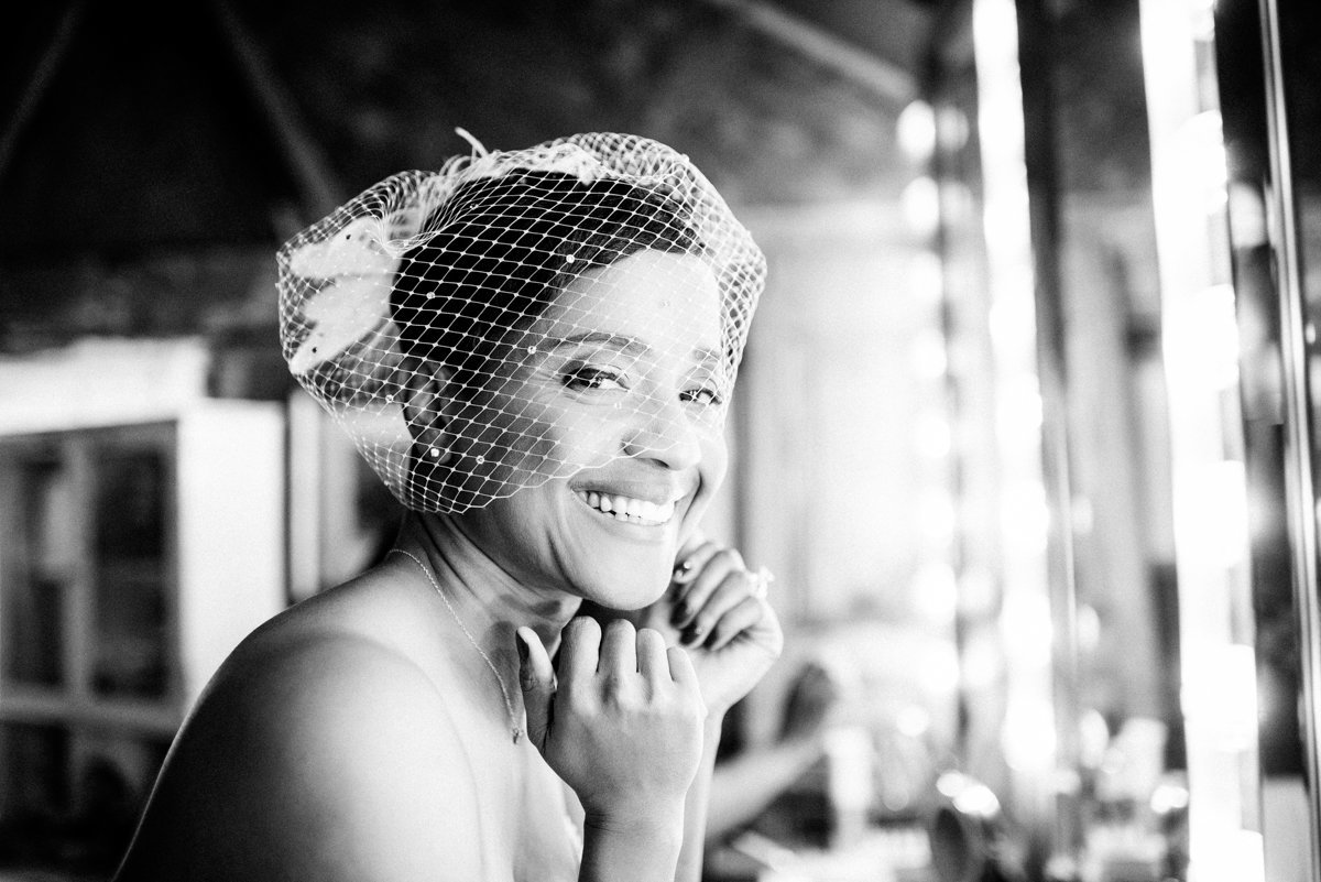 Bride wearing a cage veil getting ready in the bridal suite at Jacks Barn