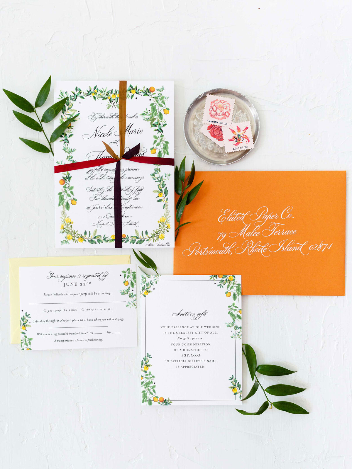 Italian wedding invitation featuring lemon and oranges with leaves and vines. Suite has an orange envelope with white guest addressing