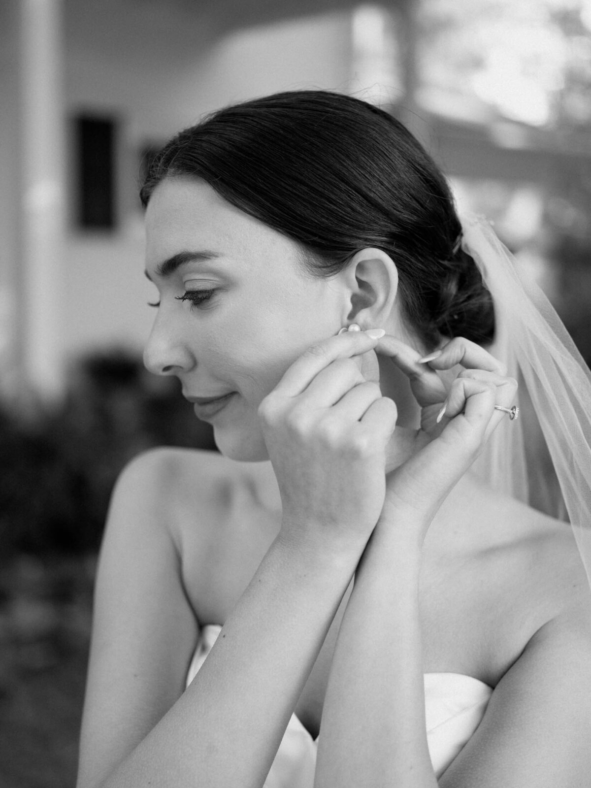 Bride putting her earrings on