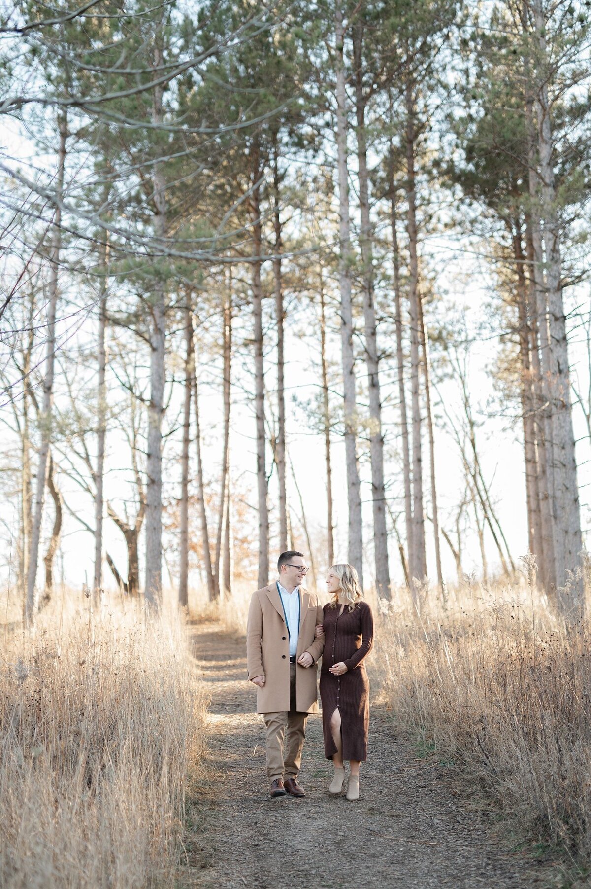 Pulled back image of a couple walking through pine trees