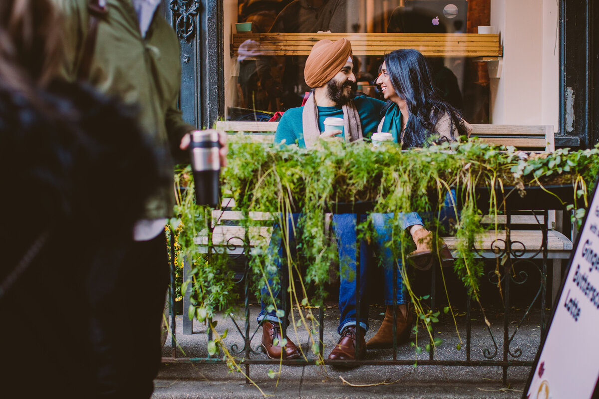 A sikh couple having coffee sitting down at a cafe outside in west village new york city