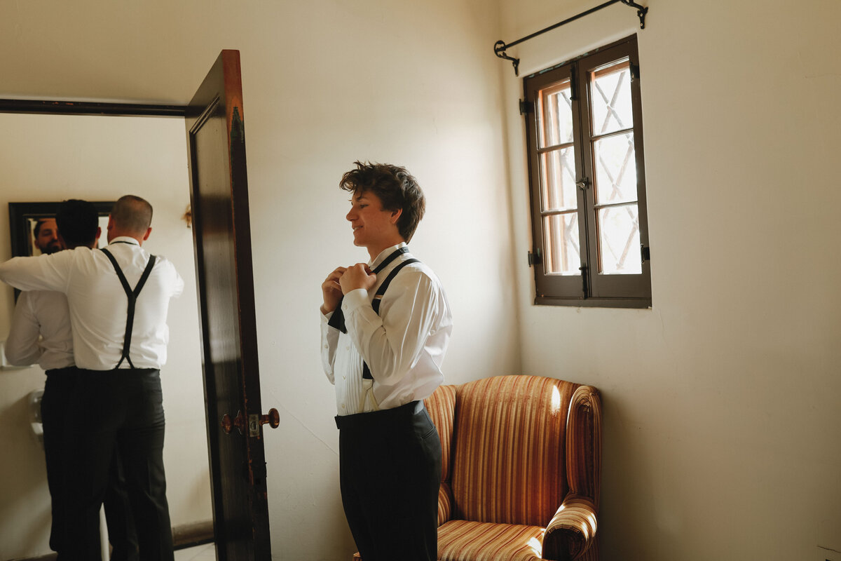 groomsmen getting ready in bathroom and adjusting ties