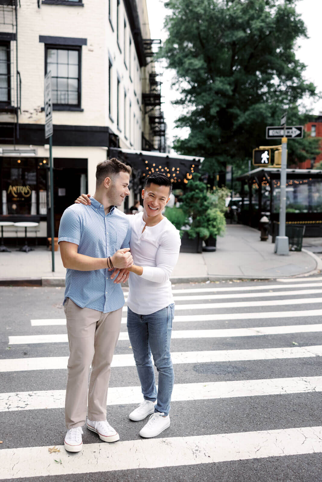The engaged man is happily looking at his fiancé's face in the middle of a street in West Village, NYC. Image by Jenny Fu Studio