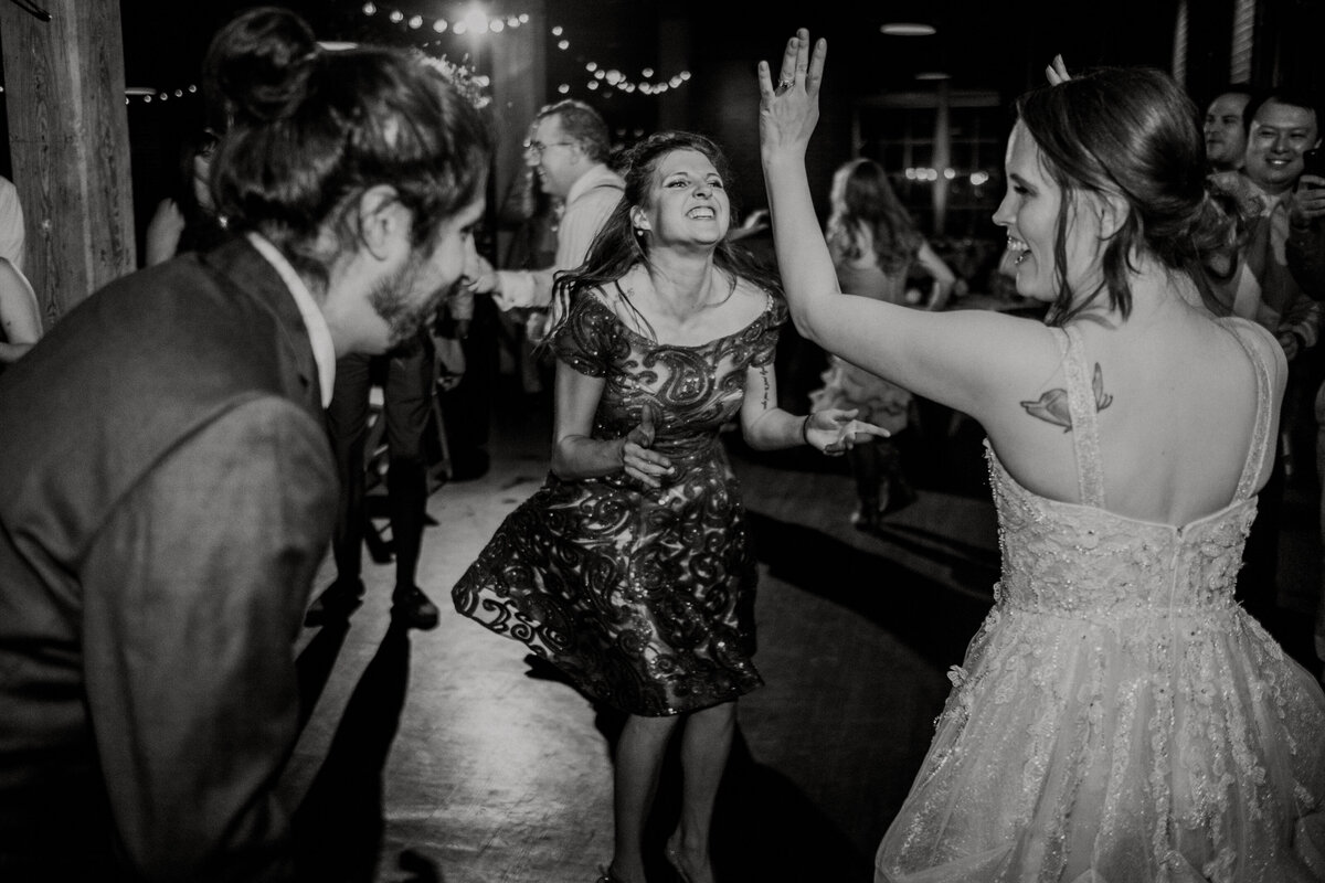 A woman is dancing with a lot of feeling along with her friends at a wedding reception
