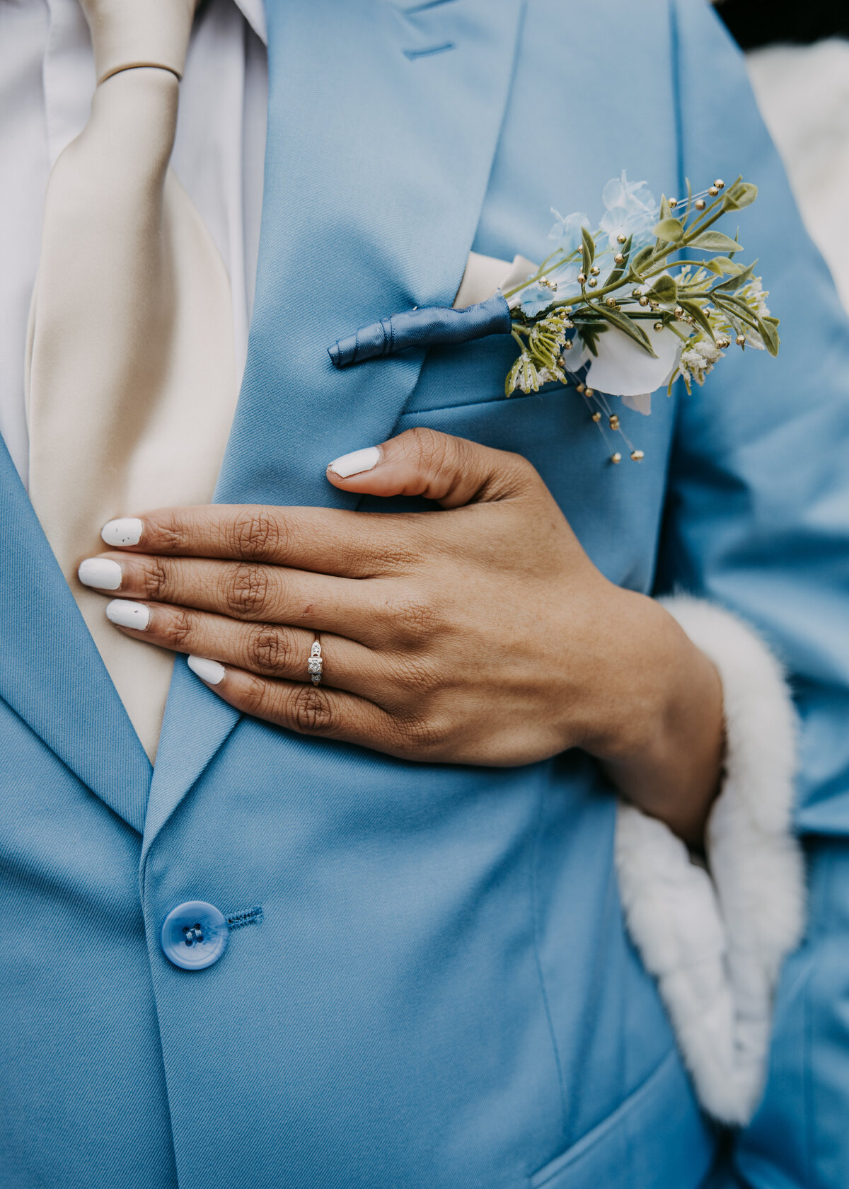 Bride's hand on groom's chest, with focus on her engagement ring, captured during their wedding at Kincaid Manor.