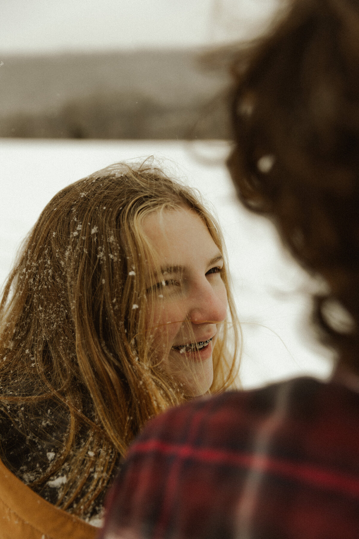 Cute photo of girlfriend smiling at boyfriend in the snow 