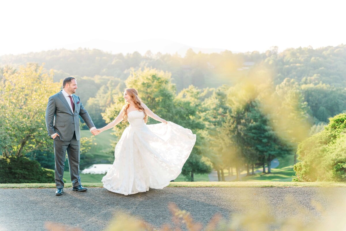 Wedding couple spins at sunset with the blue ridge mountains of NC in the background