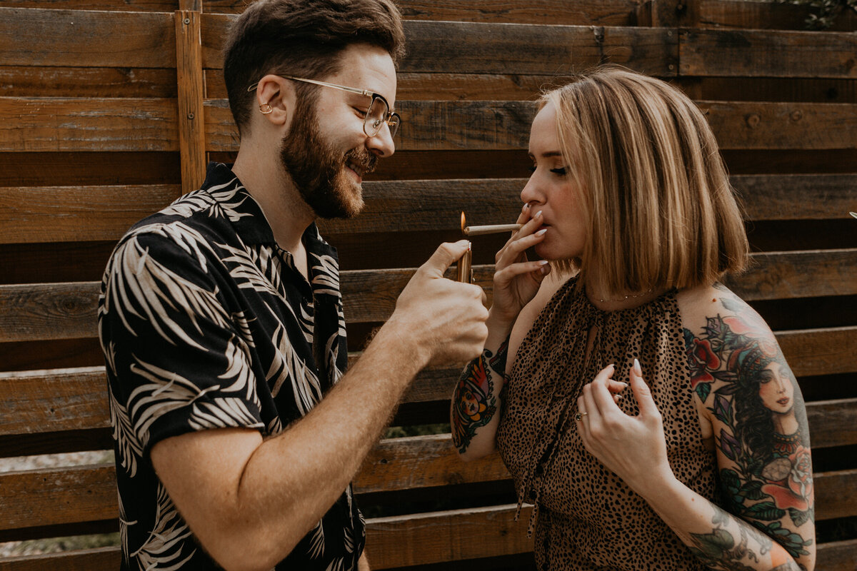 engaged couple smoking weed on porch together laughing