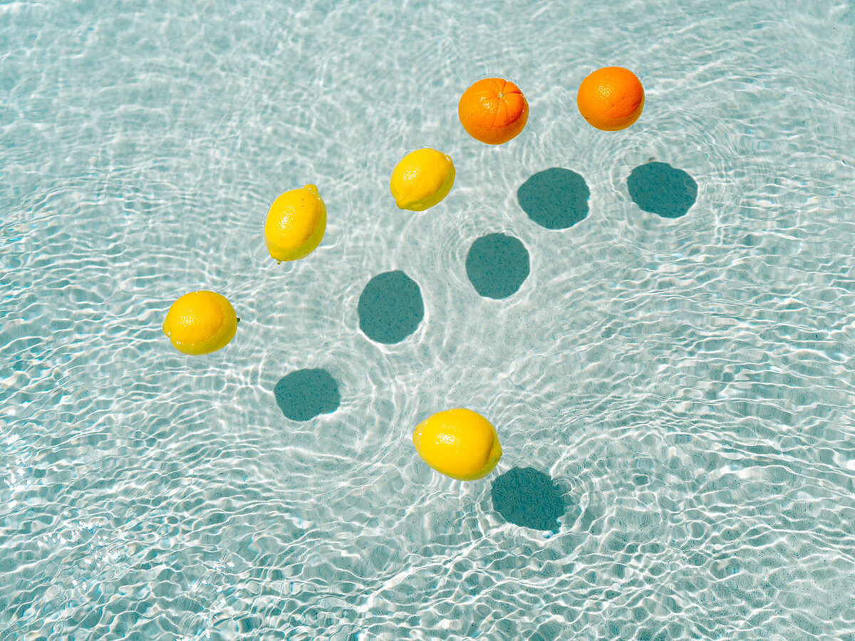 Lemons and oranges floating in pool water