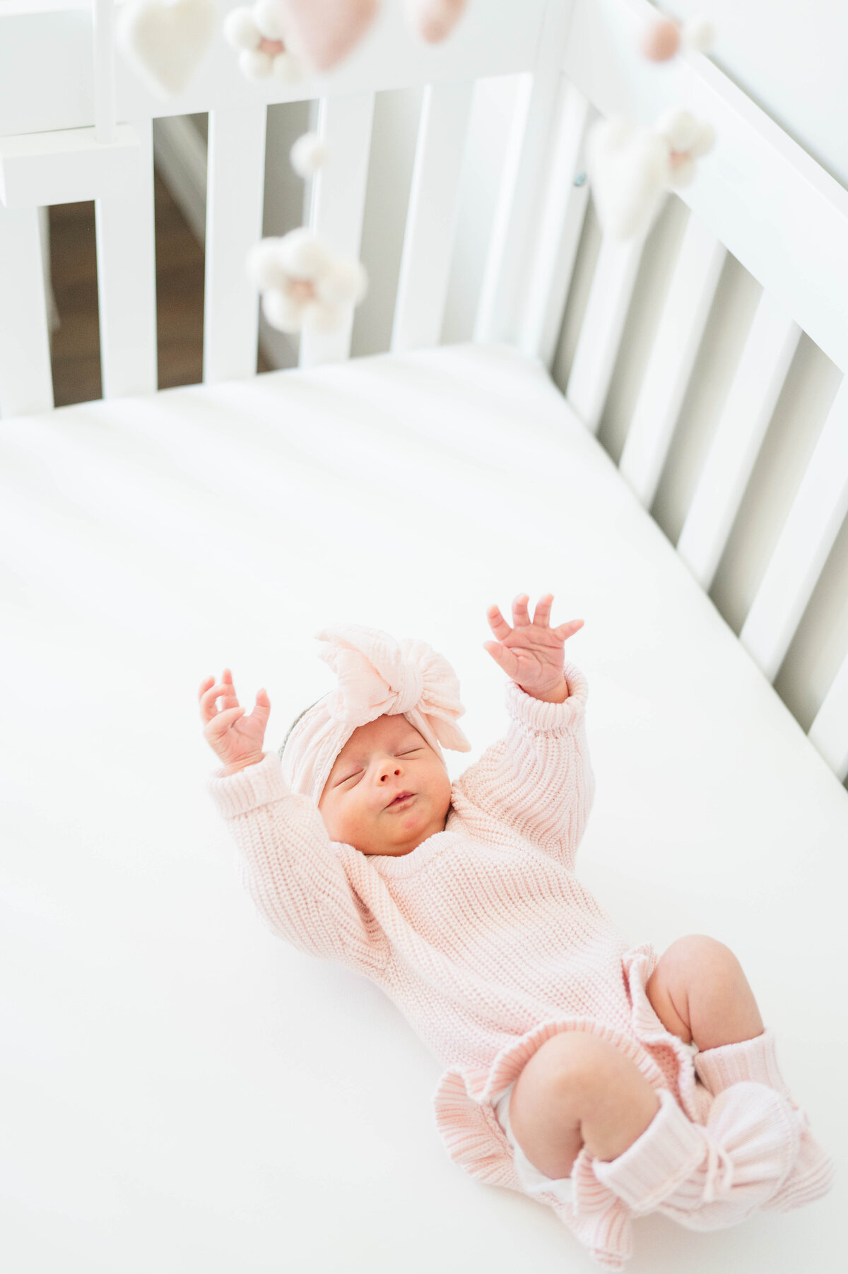 Newborn baby girl in crib taken in Douglas, MA by the best newborn photographer in central Massachsuetts