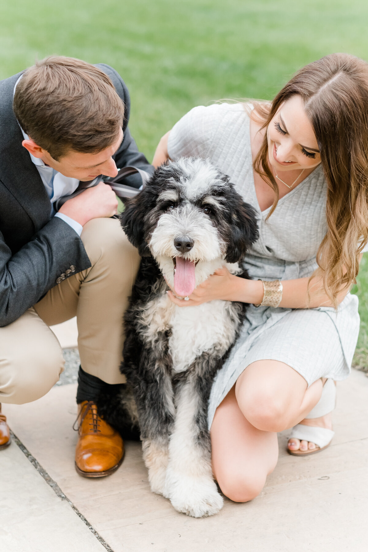 couple hugging and looking at their dog during engagement session