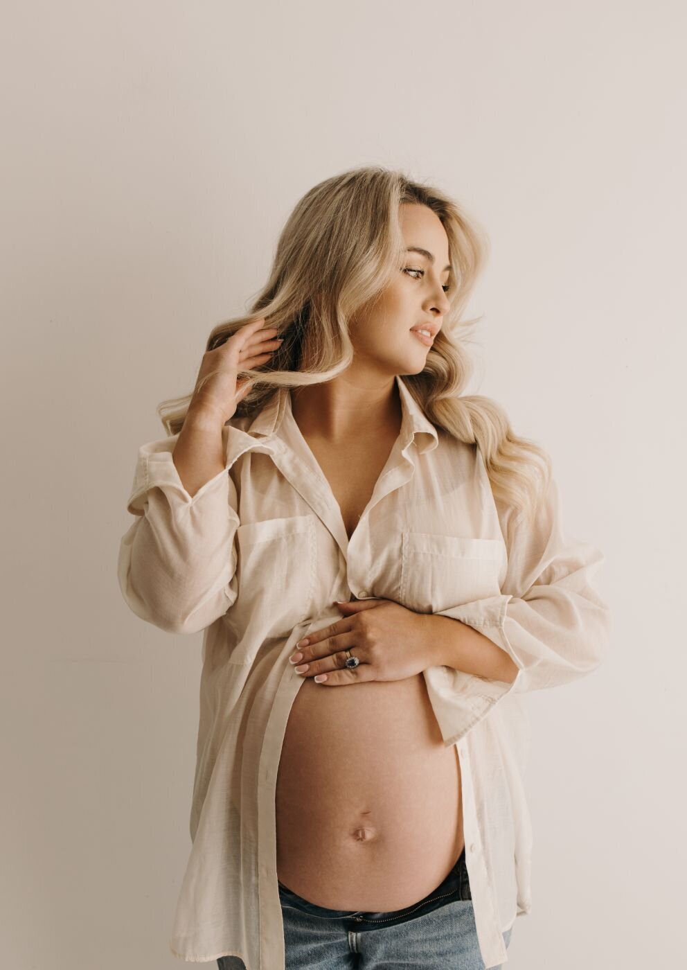 Elegant pregnant woman with blonde wavy hair in a light shirt, Mullingar maternity photography