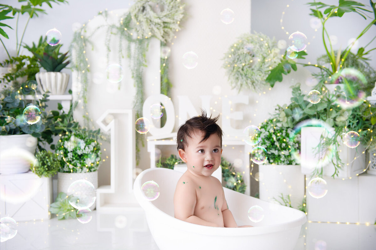 boy full of icing taking a milkbath at the end of his cake smash photoshoot in Pretoria