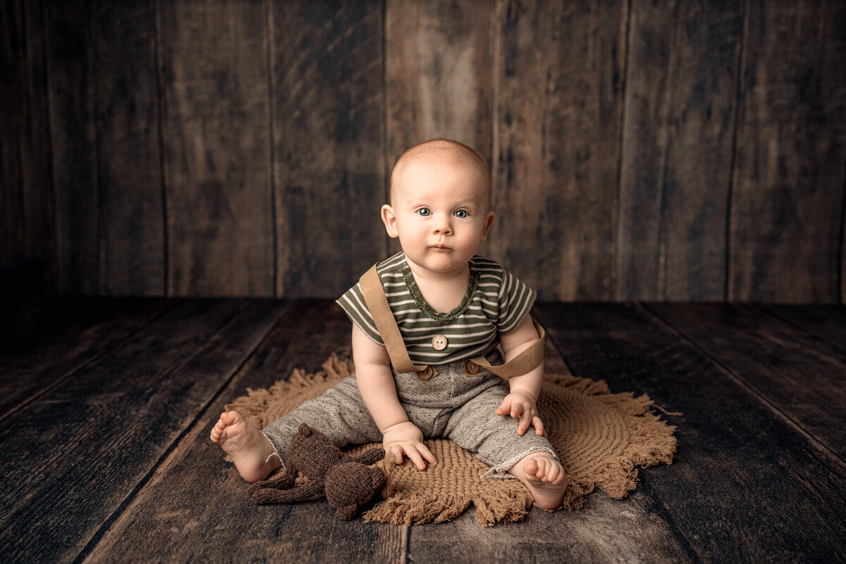 Baby boy six months sitting in suspender outfit by for the love of photography Lansing