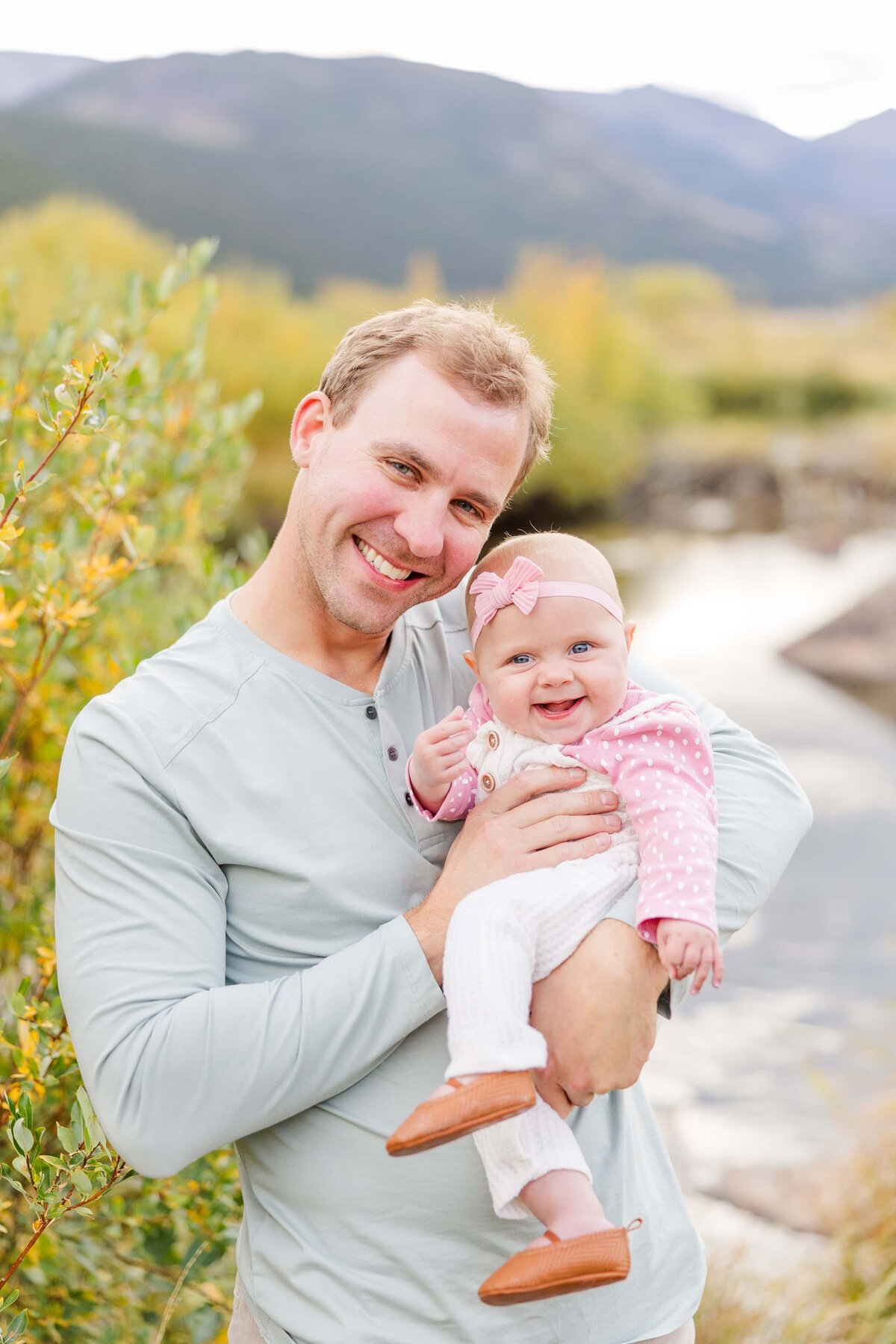 Dad and daughter laugh at camera in Moraine Park, CO