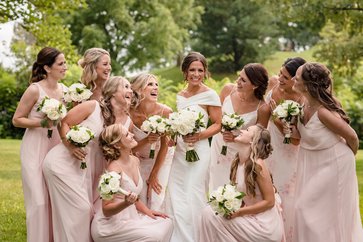 bridesmaids dressed in pink dressed look at the bride