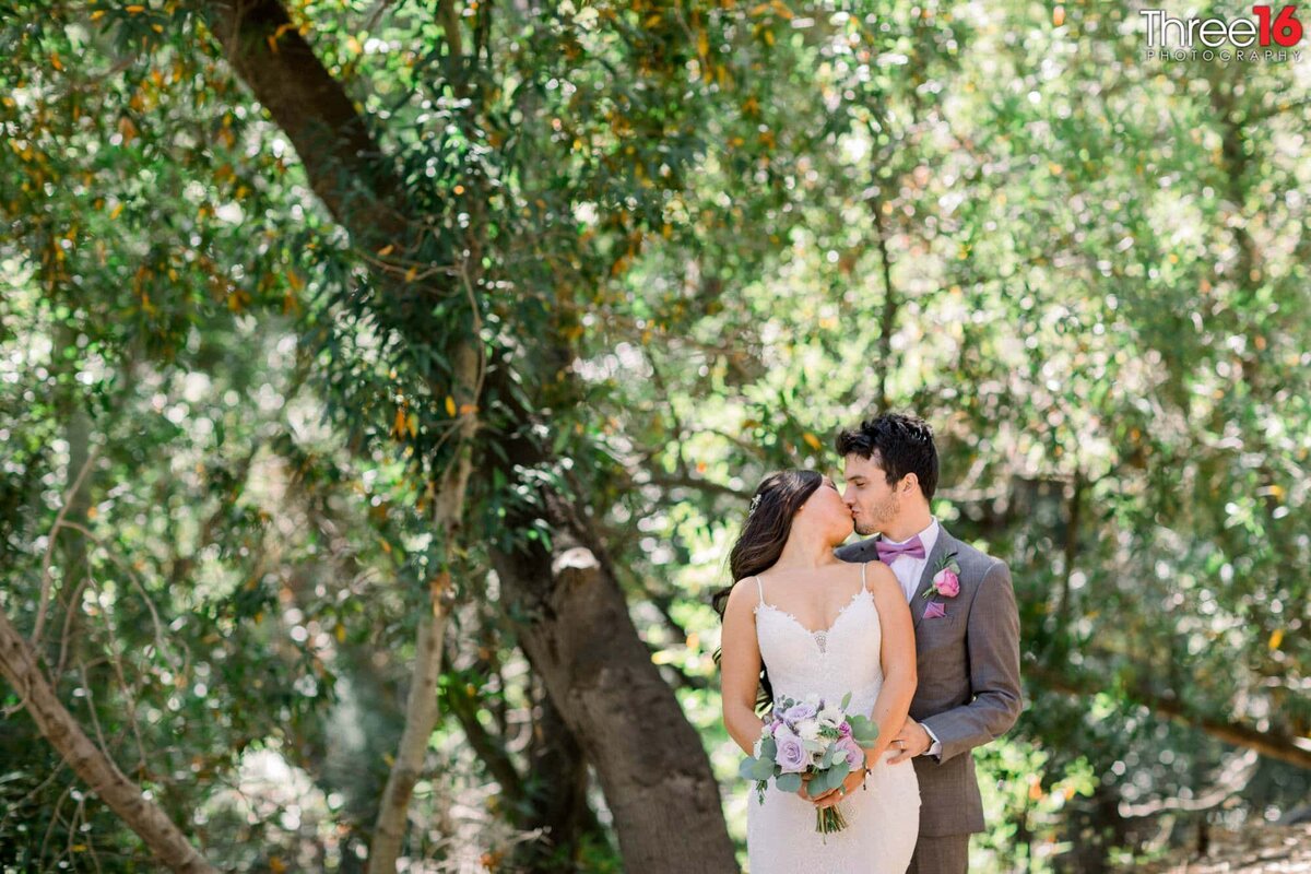 Bride leans back and shares a tender kiss with her new Groom