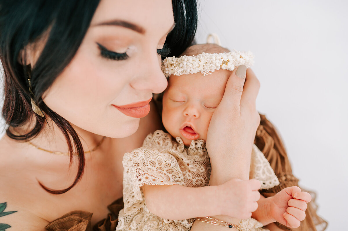 mom holding baby girls cheek during Springfield MO newborn photography session