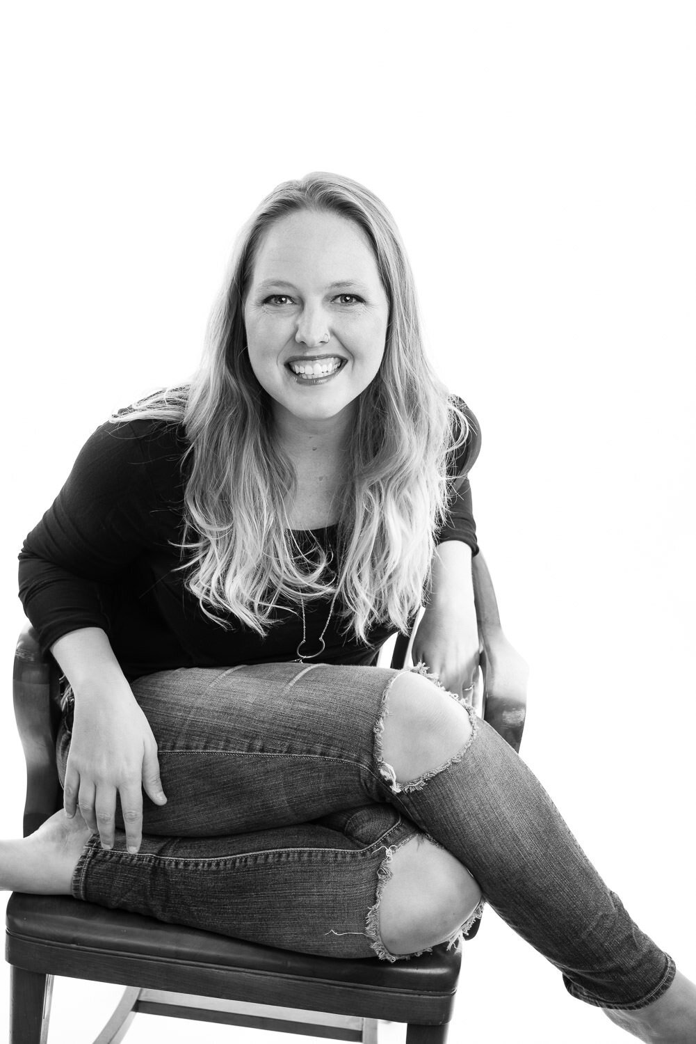 Editorial headshot of a Christian author sitting in her favorite chair against a clean white studio backdrop