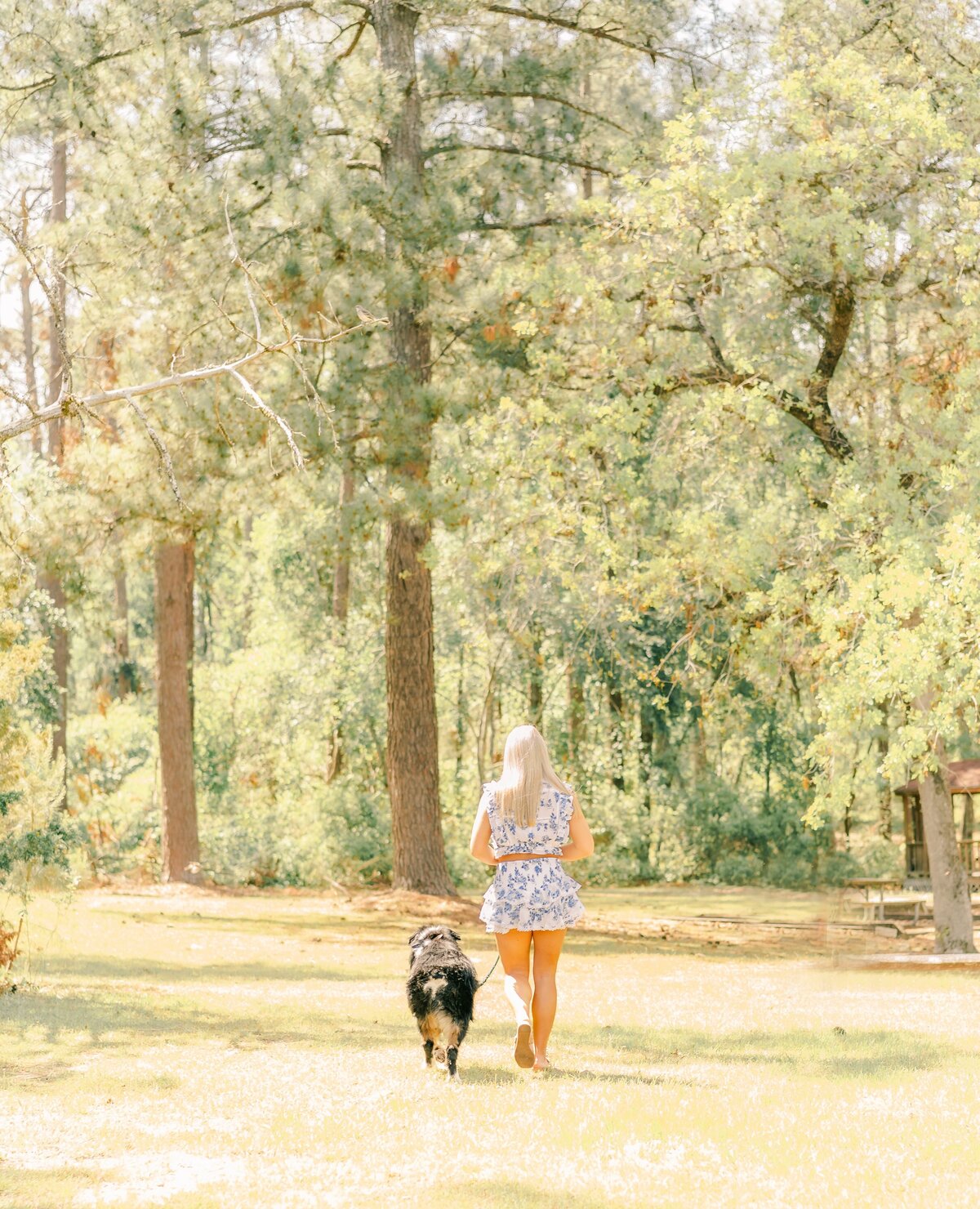 girl walking away with her dog at the end of her senior pics shoot