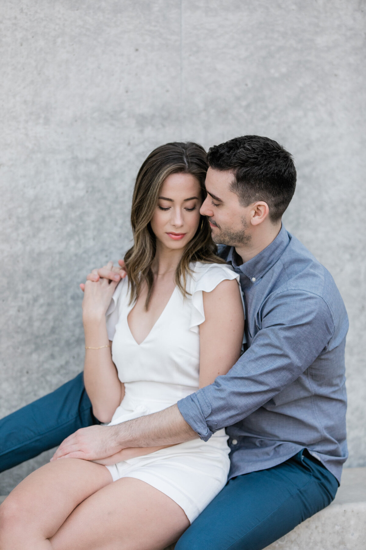 Close up of a couple sharing an intimate hug at the Kimbell Art Museum in Fort Worth during their engagement session.