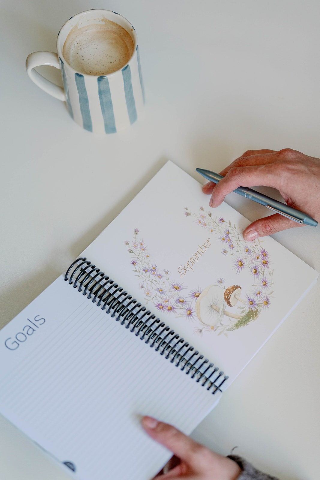 Close-up of hands holding a floral planner as part of the branding session for a planner company in Indiana.