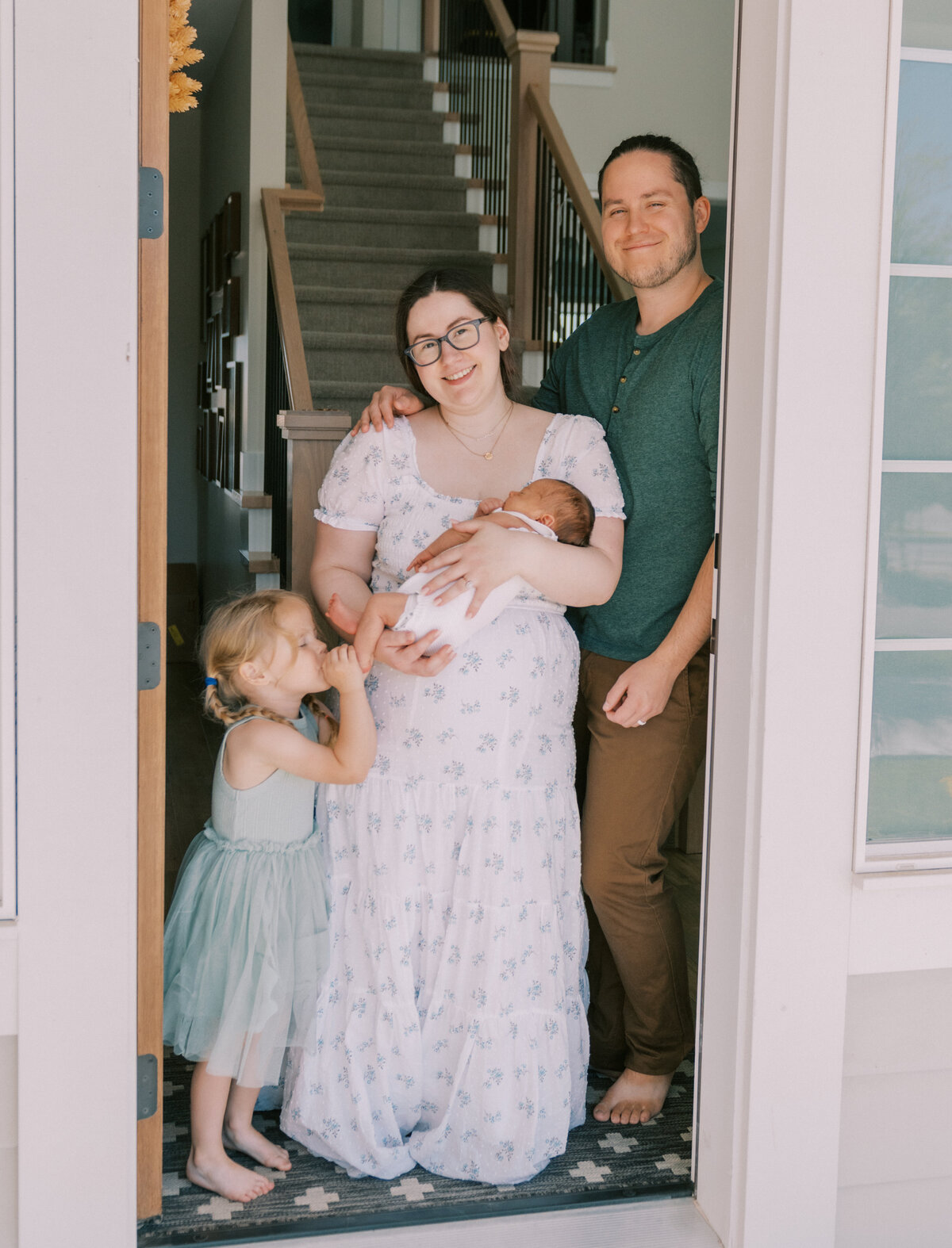 parents in home holding newborn lifestyle photos