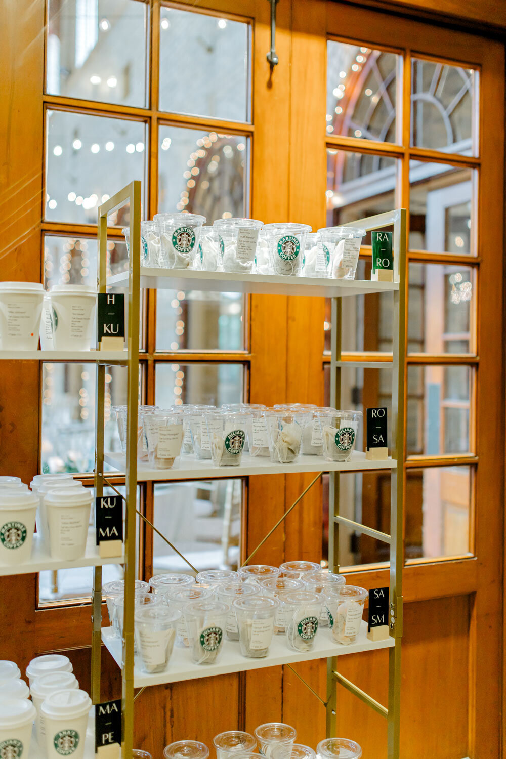 Shelves with personalized Starbucks cups for guests
