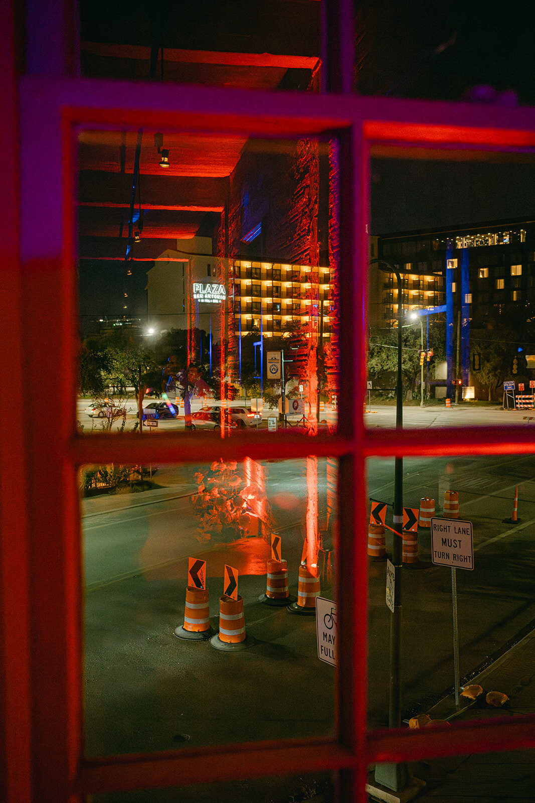 San Antonio city view captured through red-lit window at The Battalion wedding venue during upscale evening reception