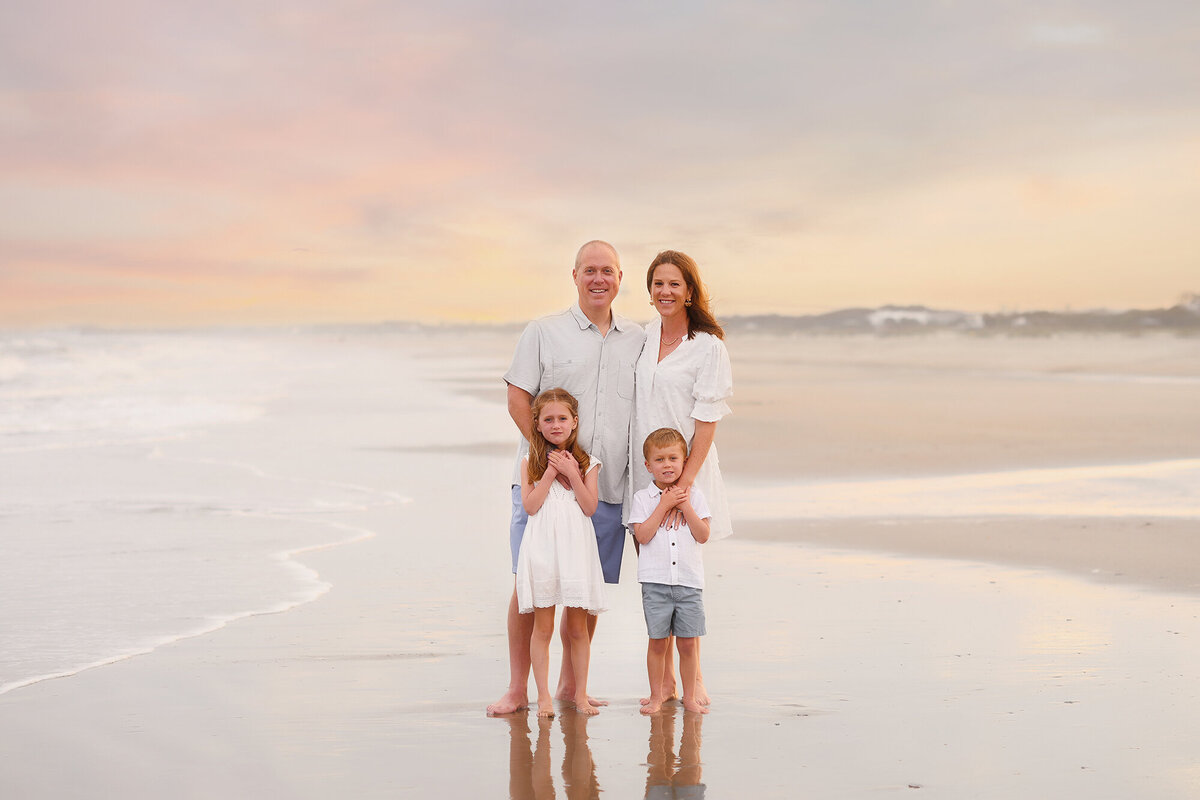 Family poses for Family Pictures on Isle of Palms beach in Charleston, SC.