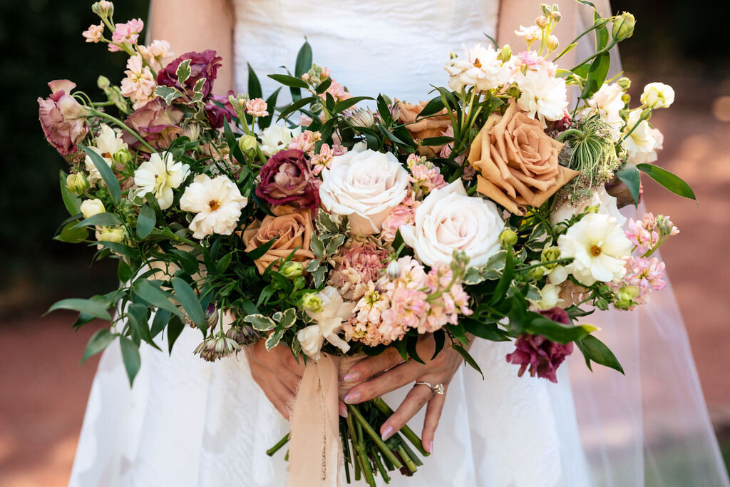 A garden-style bridal bouquet with an organic, loose arrangement of mixed blooms in neutral shades.