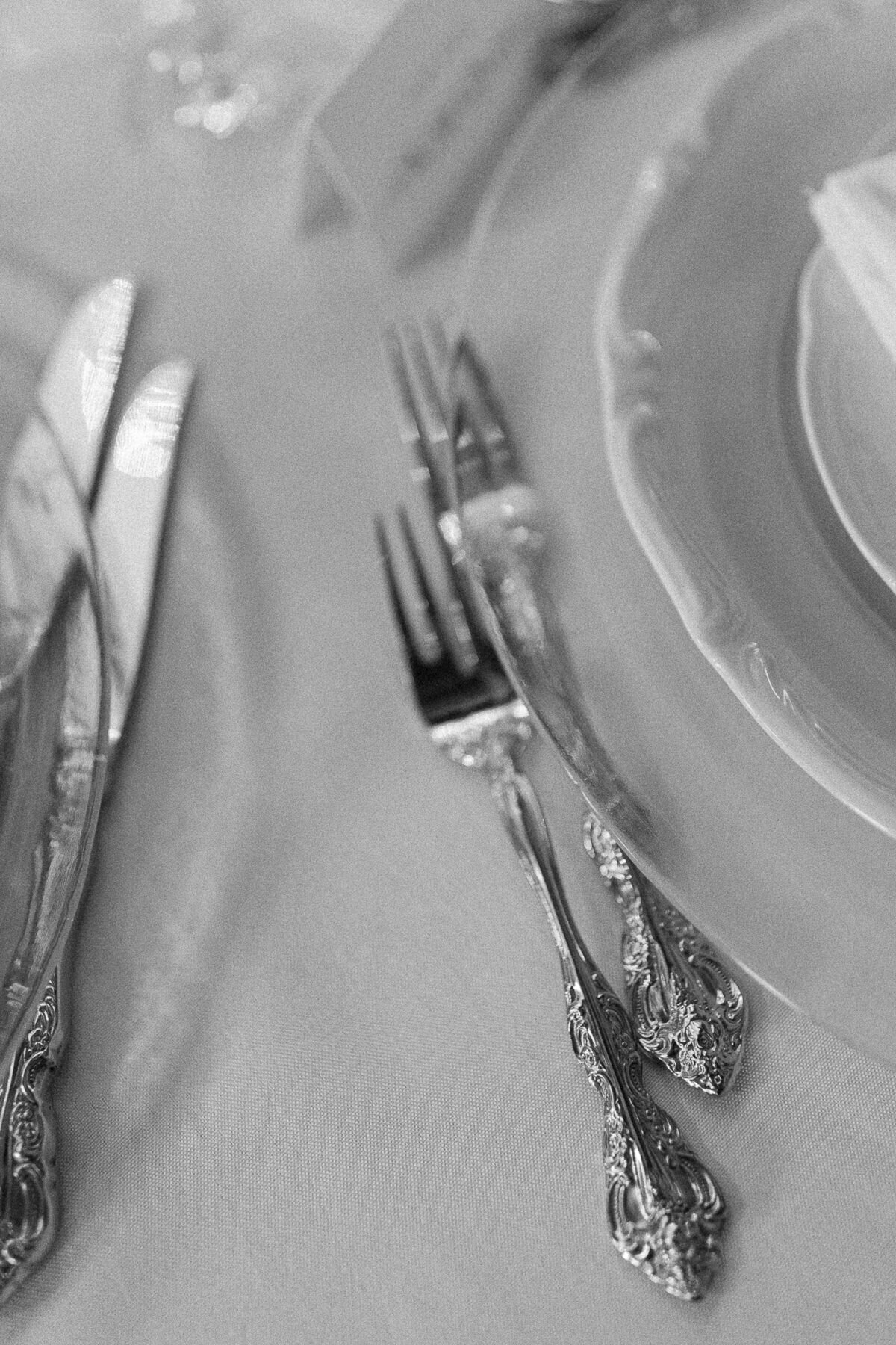 Ustensiles vintages sur table de réception lors d'un mariage au Château St-Agnes, photo en noir et blanc. 