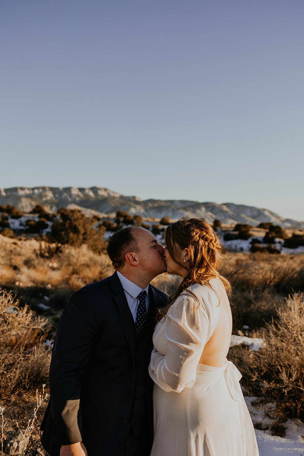 newlyweds about to kiss in the desert