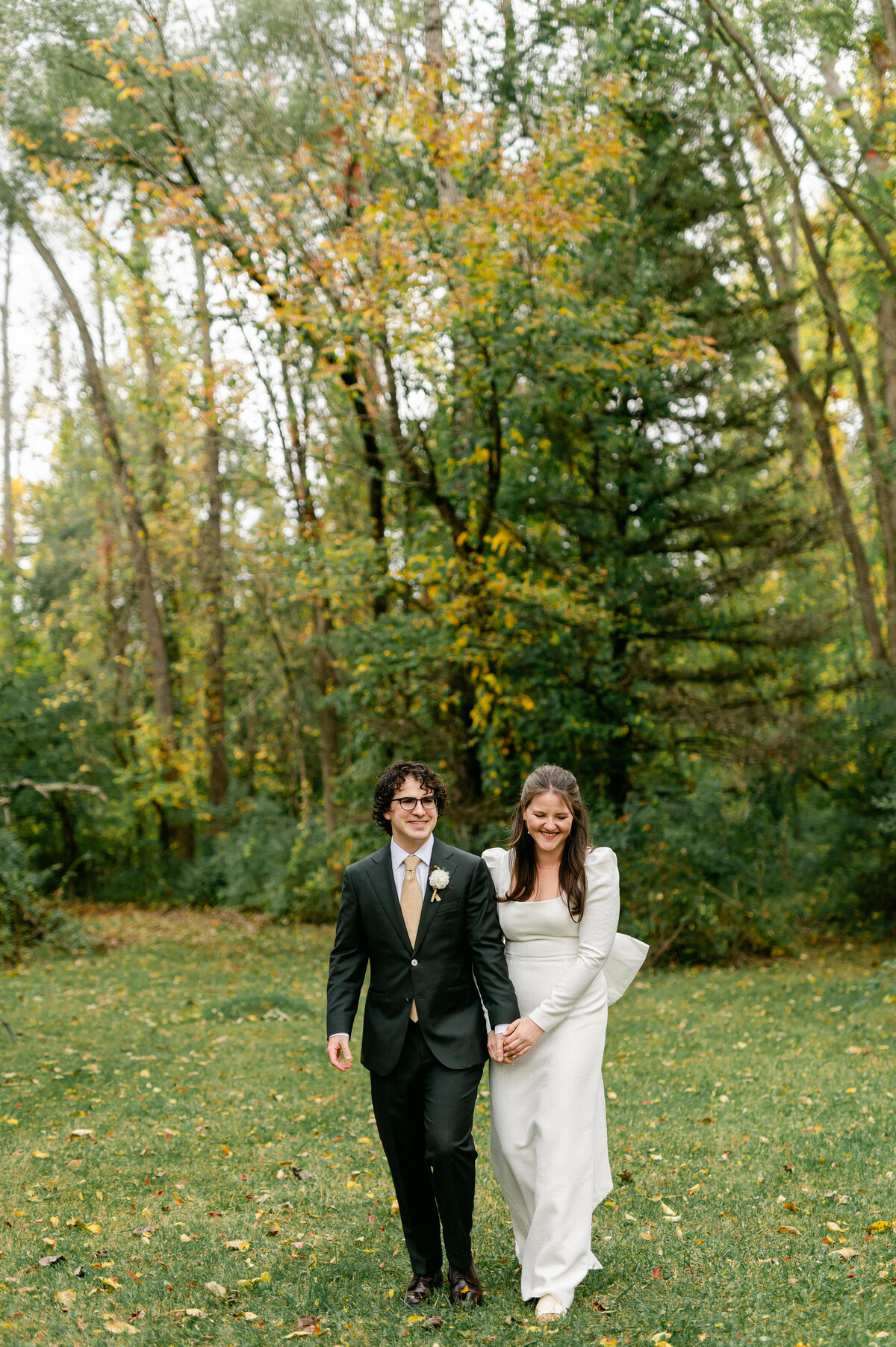 Bride and groom hand and hand walking towards camera