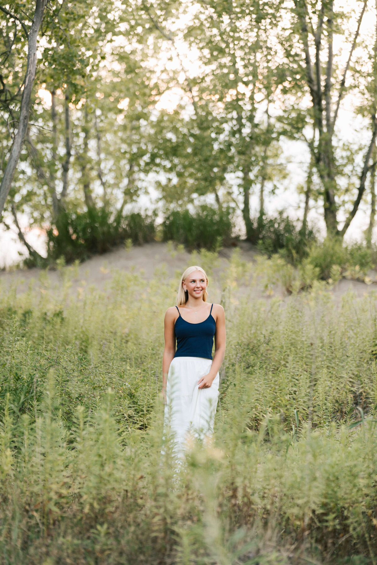 Erie Pa high school senior girl standing in the tall grass at the beach
