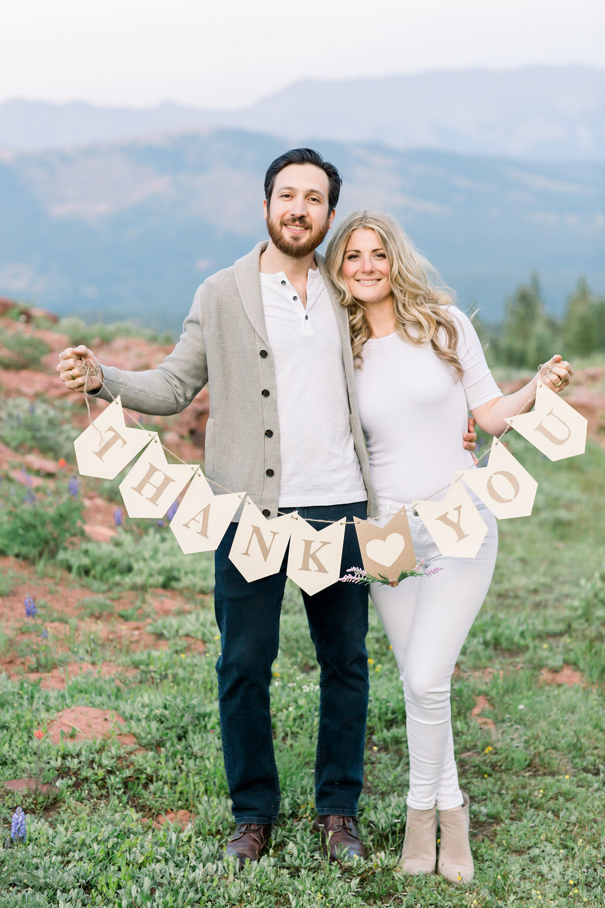 Bride and groom holding thank you banner