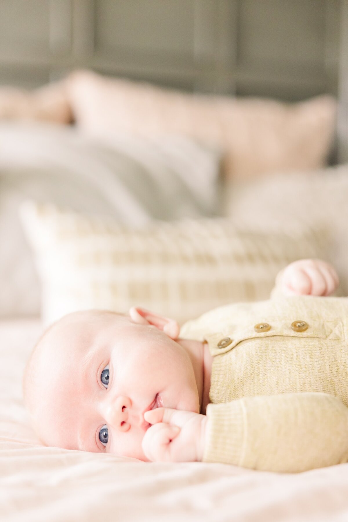 Baby boy laying and looking towards the window for Erin Thompson Photography