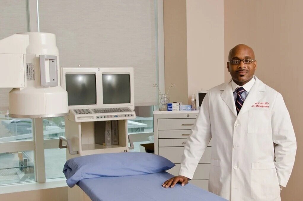 Professional headshot of doctor in white lab coat standing confidently in hospital setting new york cit