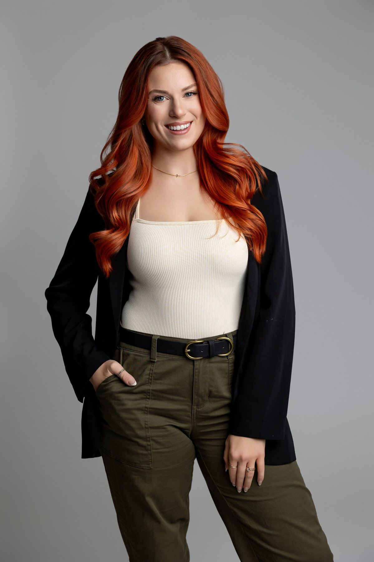 Studio branding portrait of woman with red hair looking at reflection in mirror. Photograph by Yucaipa branding photographer Kaitlyn Dawn Photography.