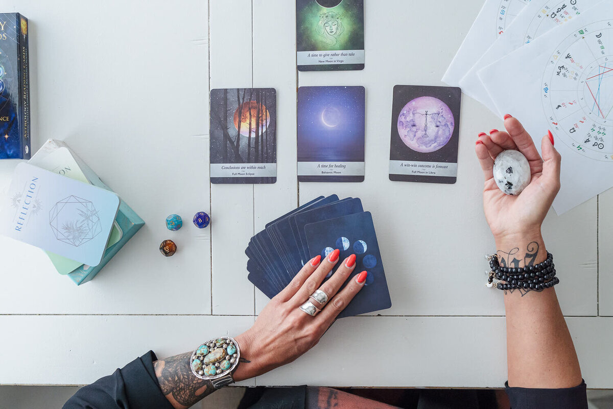 hand holding astrology tarot cards  on white table for creative branding photos