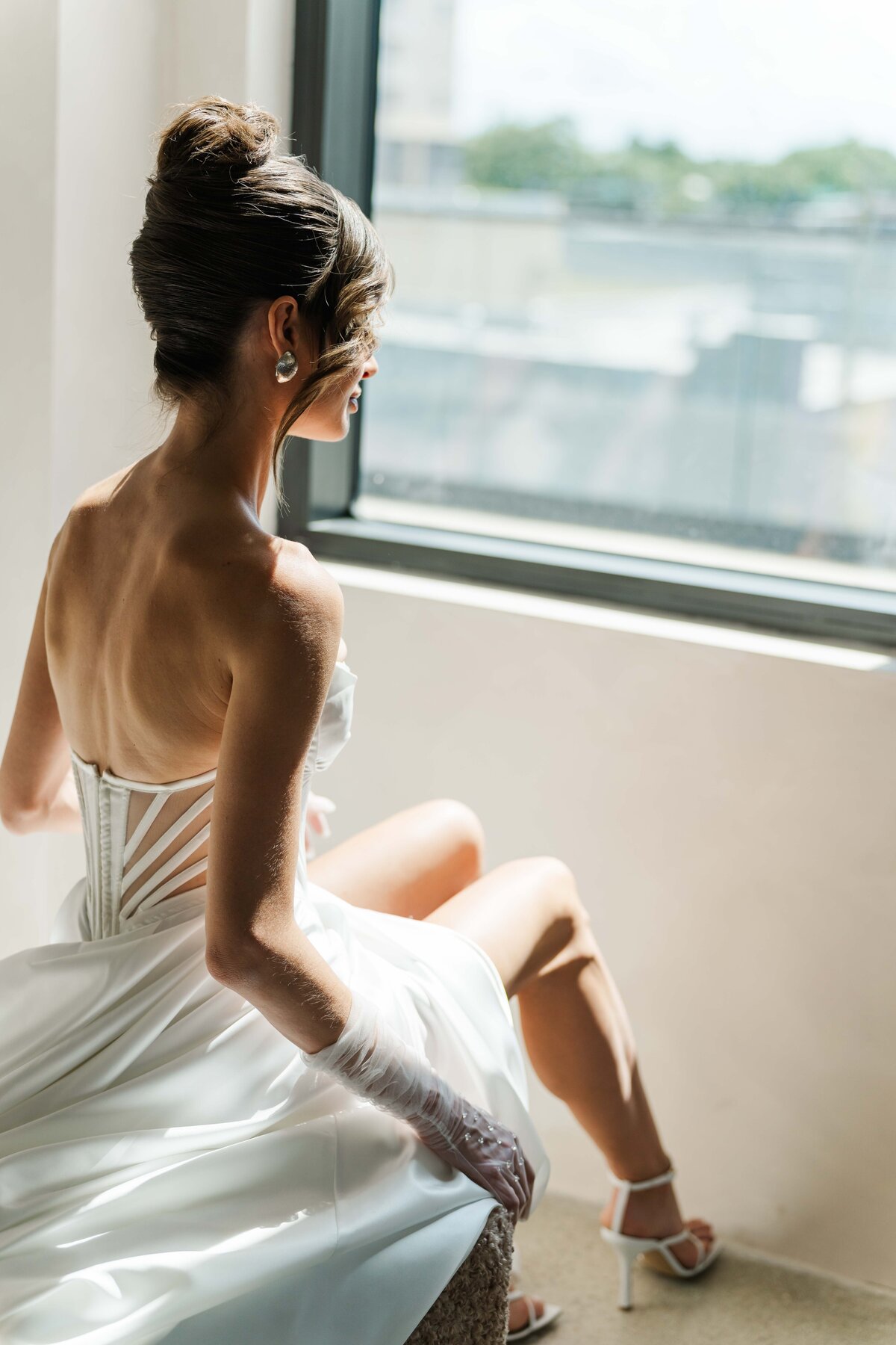bride looking otside of a window while sitting down