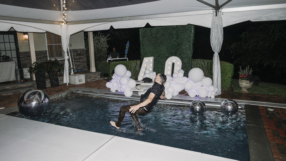 Photo of guest jumping in pool in private backyard party by Mira Park Photography NY based wedding photographer
