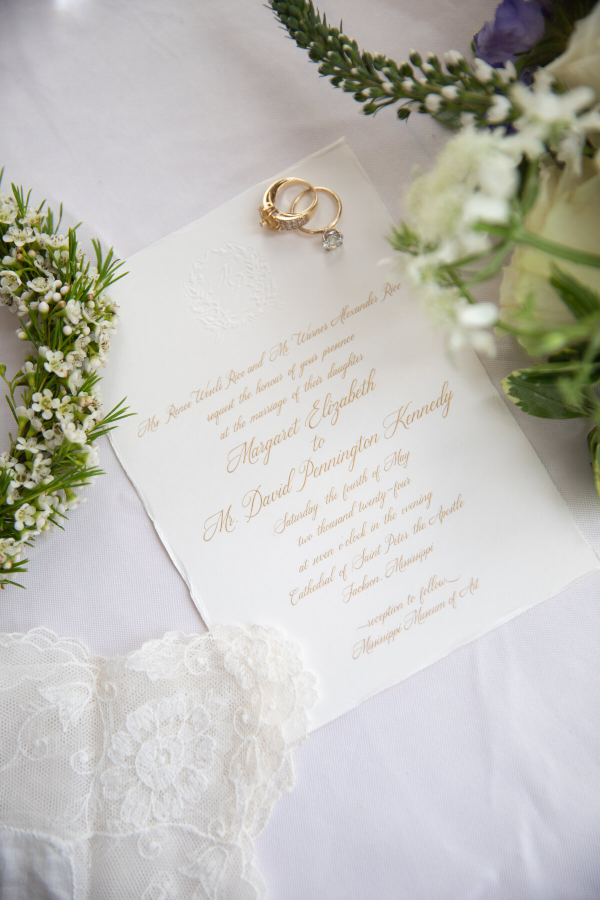 Wedding invitations featuring blind embossed monogram and gold engraving.