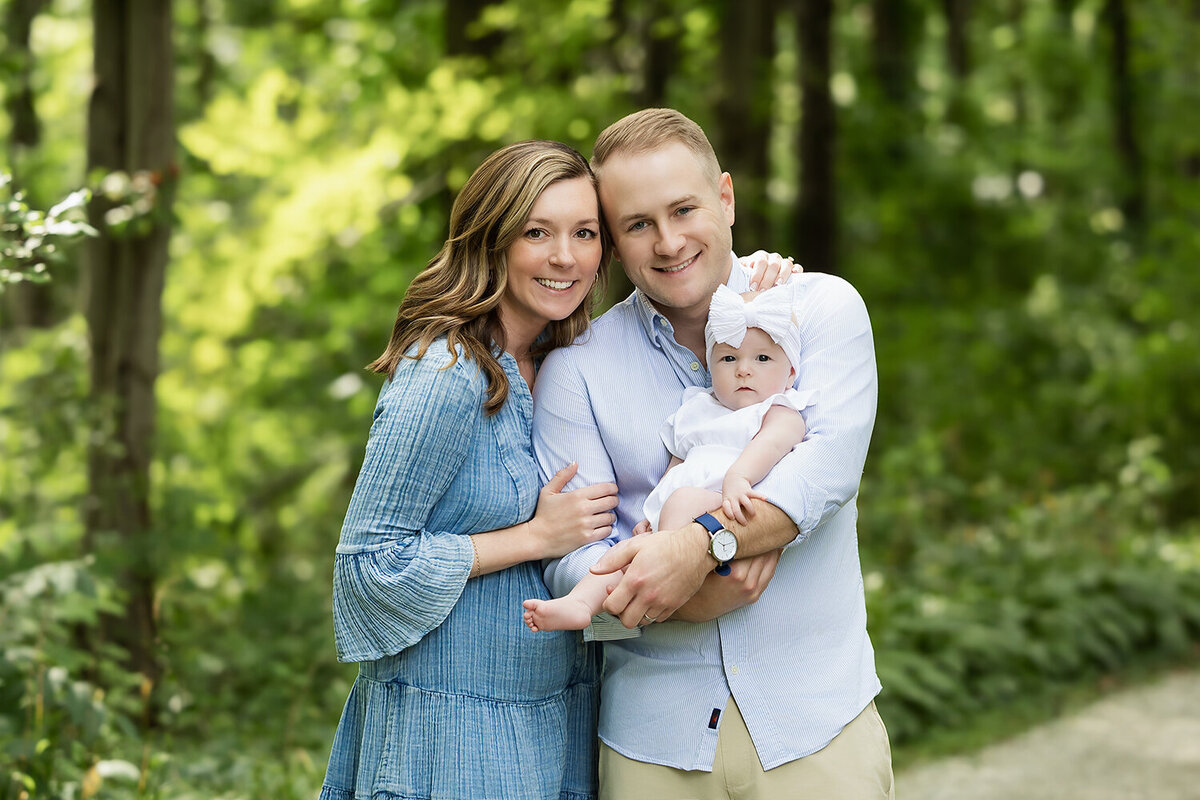 mom and dad cuddle their new baby outside their wadsworth family home 