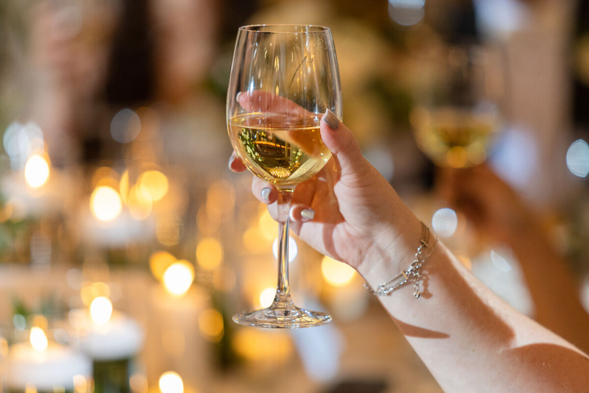 A woman is holding a glass of wine in her hand.
