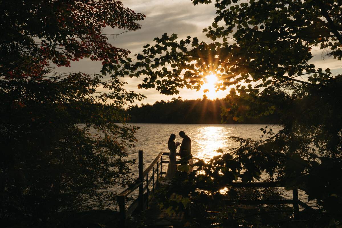 couple reading their vows privately on a dock in Maine during their summer wedding