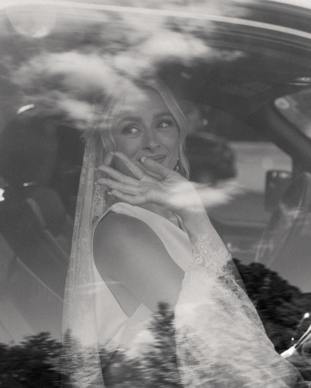 Bride waves from car window post-ceremony at Dayton, Ohio wedding, photographed by Philly-based photographer.