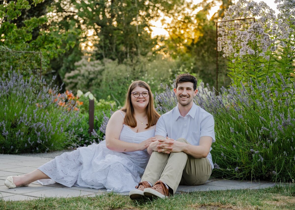 man and woman sit in flowers at bellevue botanical garden