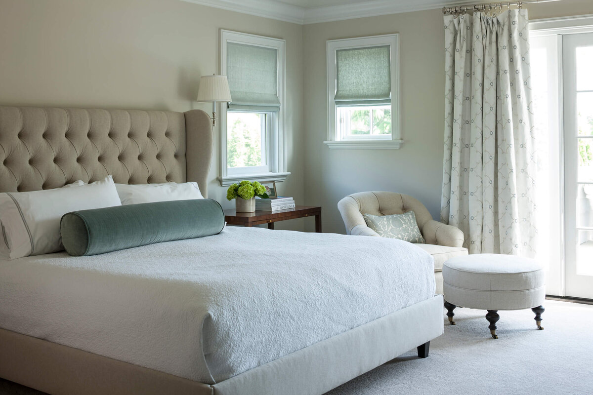 Bedroom-with-tufted-headboard-and-armchair-with-ottoman